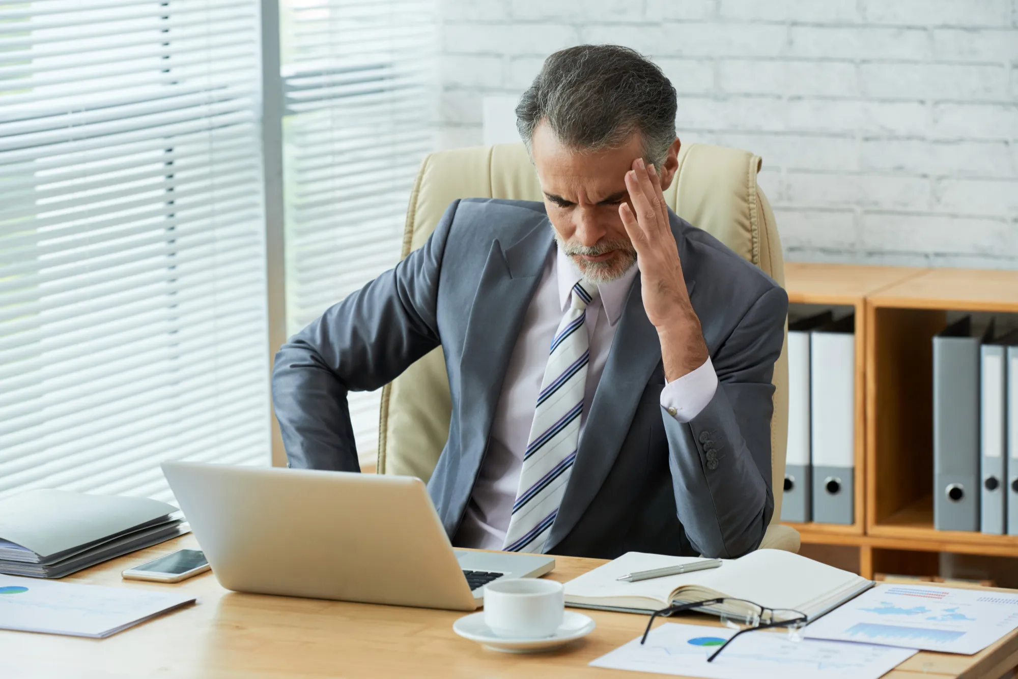 Business professional looking stressed while working on laptop